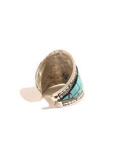 This adjustable white metal ring is hand-crafted by local artists of Nepal. It features the Om symbol in the center of the band, set off with turquoise stone chips and delicate ornate rope-like designs around both sides. The ring can be gently pressed together to adjust to whichever finger on which you choose to wear it. Measures almost 0.75 inches wide and 0.75 long. Handcrafted in Nepal. The Om Symbol, Tibetan Turquoise, Om Symbol, Stone Chips, Metal Ring, Finger Ring, Ring Finger, Local Artists, White Metal