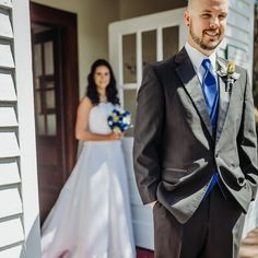 a man in a suit and tie standing next to a woman wearing a wedding dress