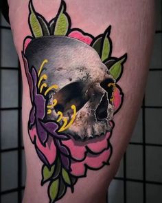 a skull and flower tattoo on the leg