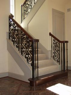 a staircase with wrought iron railing and handrail in a home's entryway