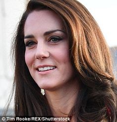 a woman with long brown hair smiling at the camera