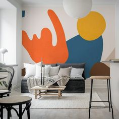 a living room with an abstract wallpaper and furniture in the foreground, two stools on either side