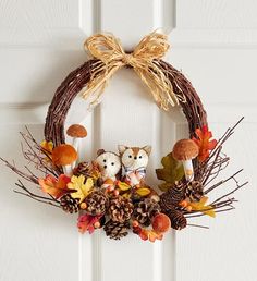 an autumn wreath with two owls and pine cones