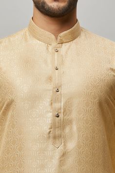 Brocade Kurta with gold embossing & placket plus gold churidar Crafted with a collar neckline, full sleeves, and front button closure. Occasion: Can be worn to lighter events like Sangeet, Mehendi, Puja, or a small party WASH CARE INSTRUCTIONS - Please Dry clean only when it is applicable. Slight color variation is possible due to digital photography. Brocade Mens Kurta, Festive Fitted Kurta With Band Neckline, Elegant Straight Kurta With Zari Weaving, Elegant Long Sleeve Kurta With Zari Weaving, Traditional Fitted Kurta With Band Neckline, Elegant Sherwani With Zari Weaving For Festive Occasions, Elegant Eid Sherwani With Zari Weaving, Traditional Semi-formal Kurta With Buttons, Elegant Designer Churidar With Zari Weaving