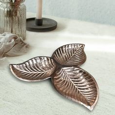 two metal leaves sitting on top of a table