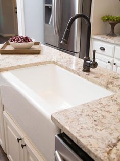 a white kitchen sink sitting under a faucet next to a dishwasher