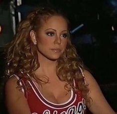 a woman in a red and white shirt sitting down