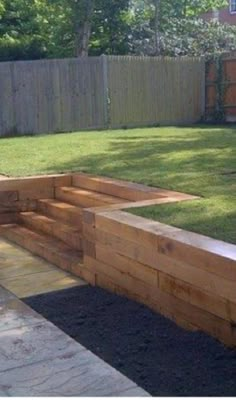 a wooden garden bed sitting in the middle of a yard