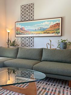 a living room with a couch, coffee table and pictures on the wall above it