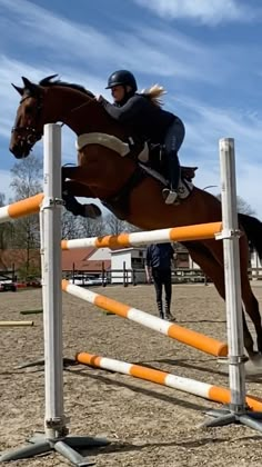 a person jumping a horse over an obstacle