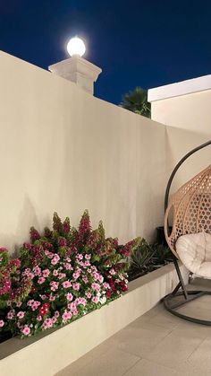 a white chair sitting on top of a patio next to flowers