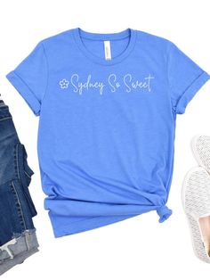 Look your sweetest in the official Sydney So Sweet tee! Made of a blissfully soft cotton blend, this high-quality short sleeve shirt comes in six delicious colors and seven sizes, so you're sure to find your perfect fit. Plus, show off your love of this sweet company! INCLUDES: T-Shirt UNISEX SIZES: XS, S, M, L, XL, XXL, XXXL FIT: This item is true to size. FABRIC & CARE: Machine Washable 100% combed and ring spun cotton (fiber content may vary for different colors) Bella + Canvas Brand This cla Sweet Short Sleeve Cotton T-shirt, Sweet Style Short Sleeve Cotton T-shirt, Sweet Cotton T-shirt With Short Sleeves, Sweet Summer T-shirt With Crew Neck, Summer Sweet T-shirt With Letter Print, Cute Soft-washed Short Sleeve T-shirt, Sweet Summer T-shirt With Letter Print, Cute Blue Soft-washed T-shirt, Cute Soft-washed Blue T-shirt