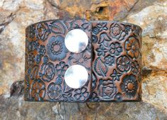 This by far one of the most stunning handcrafted 2 inch WIDE BRACELET CUFFS! It has such artistic detail with a gorgeous flower garden with a hidden butterfly just minding her own business as happy as she can be amongst all the flowers. It is stained stained a lovely antique medium brown. Two durable snaps hold this bracelet together. Surely a brilliant accessory to any outfit!Made with 100% leather! Though it is sealed twice for water resistance and durability, if water does get on it please wi Hand Tooled Cuff Jewelry For Gifts, Handmade Adjustable Cuff Bracelet, Hand Tooled Cuff Bracelets As A Gift, Hand-tooled Cuff Bracelets As Gift, Hand Tooled Cuff Bracelet For Gift, Hand Tooled Cuff Bracelet As Gift, Adjustable Hand-tooled Cuff Bracelet For Gifts, Bracelet Cuffs, Leather Bracelet For Women