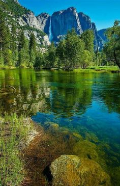 the water is clear and blue with mountains in the background