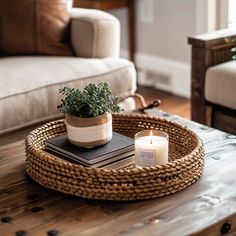 a wicker coffee table with a candle and book on it in a living room