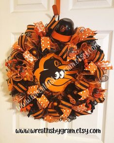 the wreath is decorated with an orange and black baltimore orioles team logo on it's front door