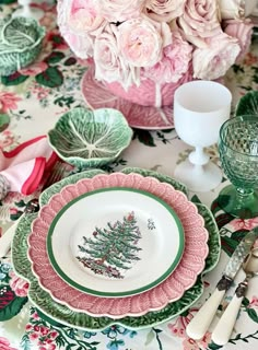 a table topped with pink roses and green plates