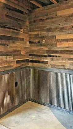 the corner of a room made out of wooden planks and corrugated sheets is empty