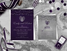 purple and silver wedding stationery on marble table with shoes, ring, cell phone