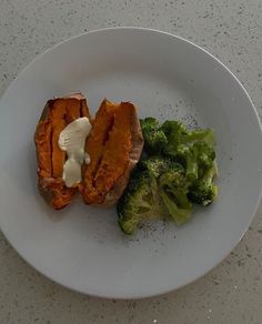 a white plate topped with broccoli and sweet potatoes