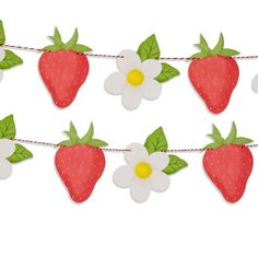 paper strawberries and daisies are hanging on a string