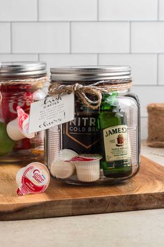 jars filled with different types of condiments on top of a wooden cutting board