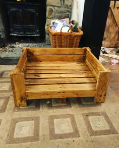 a wooden bench sitting on top of a tile floor next to a fire place with a basket