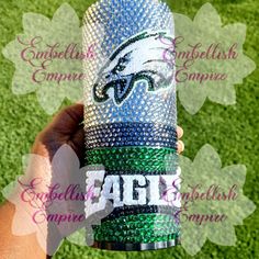 someone is holding up a can cooler with the philadelphia eagles on it in front of some green grass