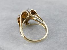 Pretty and easy to wear, this outstanding vintage cocktail ring is set with a gleaming pearl, surrounded by a sophisticated halo of yellow gold and sparkling diamonds. This piece is a true classic, a must for one's collection! Metal: 14K Yellow Gold Gem: Pearl Gem Measurements: 7.5 mm, Round Accents: 6 Diamonds totaling .20 Carats, G in Color, VS in Clarity Ring Size: 6.25 Marks: "14K" Stamped on the inside band Diamond Gold Ring, Right Hand Ring, Vintage Cocktail Ring, Gold Statement Ring, Right Hand Rings, Hand Ring, Vintage Cocktail, Diamond Gold, Vintage Pearls