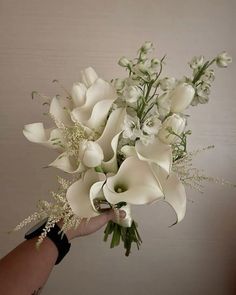 a hand holding a bouquet of white flowers