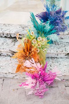 two bouquets of flowers sitting on the ground next to each other