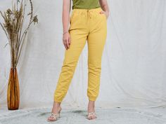 "AUNT GERTRUDE PRESENTS - vintage yellow linen pants - elastic waist - 2 pockets - materials: linen CONDITION (1-10 ❶❷❸❹❺❻❼❽❾ Great condition. SIZE/MEASUREMENTS size from label: EUR 38, FR 40, GB 10 best fits: M/L waist: 31,5-39,5 inches (80-100 cm) hips: 39,5 inches (100 cm) rise: 10 inches (25 cm) length: 39,5 inches (100 cm) inseam: 31 inches (78 cm) The model is 5'9\" (174 cm), measures 35-27-38 (90-69-96 cm) and wears size M" Summer Linen Cargo Pants With Tapered Leg, Yellow Straight Pants With Elastic Waistband, Yellow Pants With Elastic Waistband, Ankle-length Yellow Pants With Pockets, Yellow Ankle-length Pants With Pockets, Casual Mustard Bottoms For Loungewear, Casual Yellow Cotton Bottoms, Relaxed Fit Yellow Pants With Pockets, Yellow Relaxed Fit Pants With Pockets