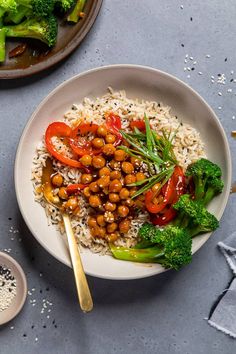 a white plate topped with rice, broccoli and chickpeas