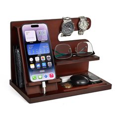 an iphone charging station with glasses, watch and cell phone on it's stand