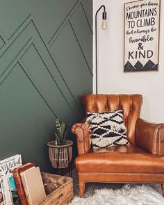 a brown leather chair sitting on top of a rug next to a wooden box filled with books