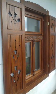 a wooden window with decorative carvings on the side