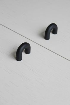 two black handles on a white painted cabinet