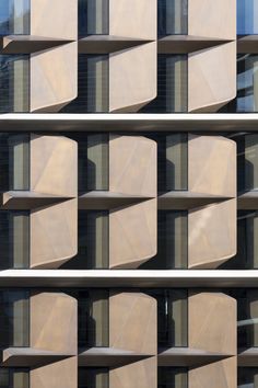 the side of a building that has several windows and shelves on each wall, all in different shapes and sizes