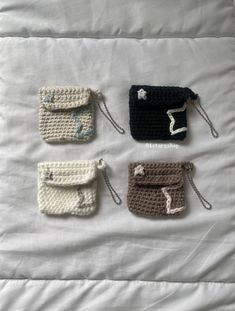 four small crocheted purses on a white bed with the handles down and one has a zippered closure