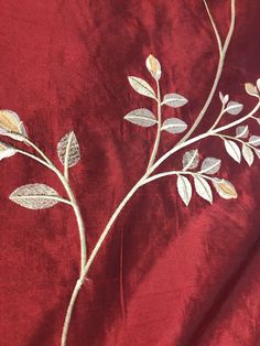 an embroidered red fabric with silver leaves on it