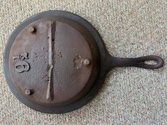 an old cast iron skillet with numbers on the side and holes in the middle