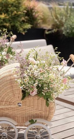 a wicker baby carriage with flowers in it