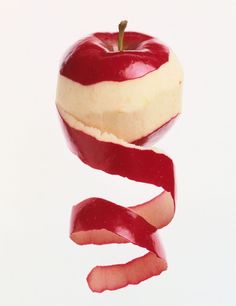 an apple with a bite taken out of it and the peel still attached to it