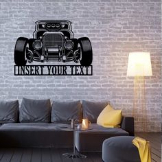 a living room with a gray couch and white brick wall behind it is an image of a vintage car