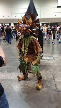 a man dressed in costume standing next to a group of people at an indoor event