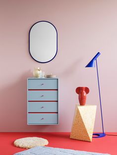 a pink and blue room with a mirror on the wall next to a chest of drawers