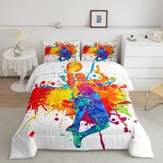 a bed with colorful paint splattered on it and a basketball player in the middle