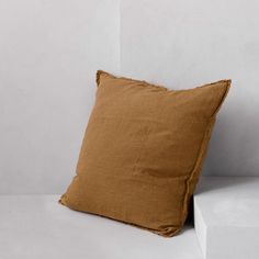 a brown pillow sitting on top of a white shelf