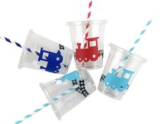 four plastic cups with straws in the shape of trains and cars, one has a blue stripe