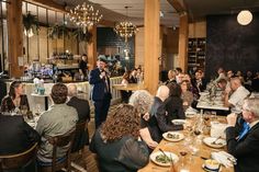 a group of people sitting at tables in a restaurant